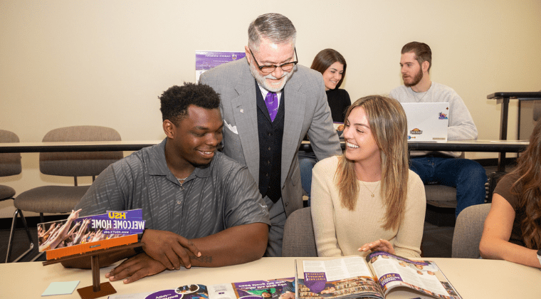 Dr. Doug McIntyre, Hardin-Simmons professor, discusses marketing collateral with students in the Kelley College of Business and Professional Studies undergraduate program.